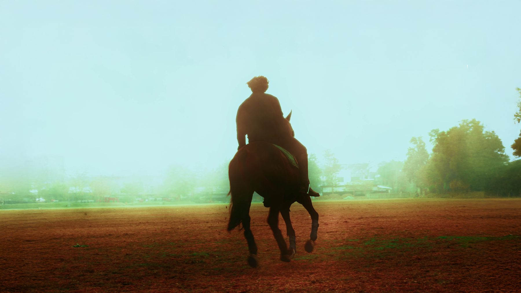 Riding across a misty field